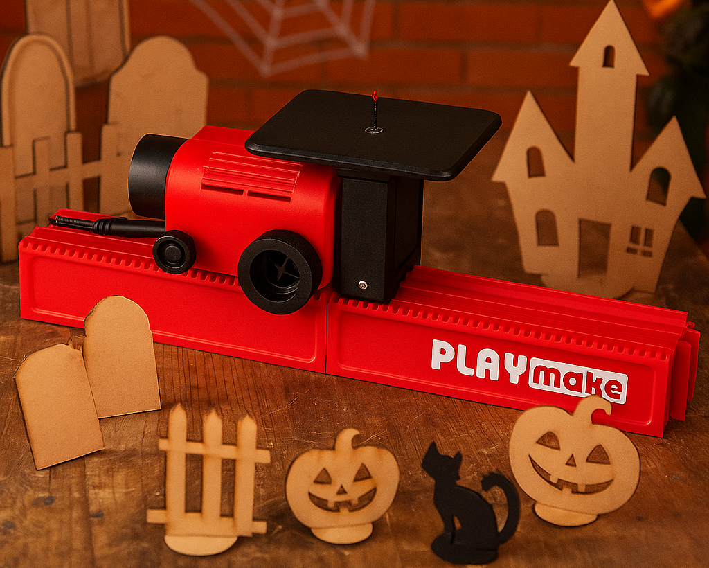 PLAYmake Stichsäge auf einem Tisch mit Holzmodellen und Projekten aus Karton