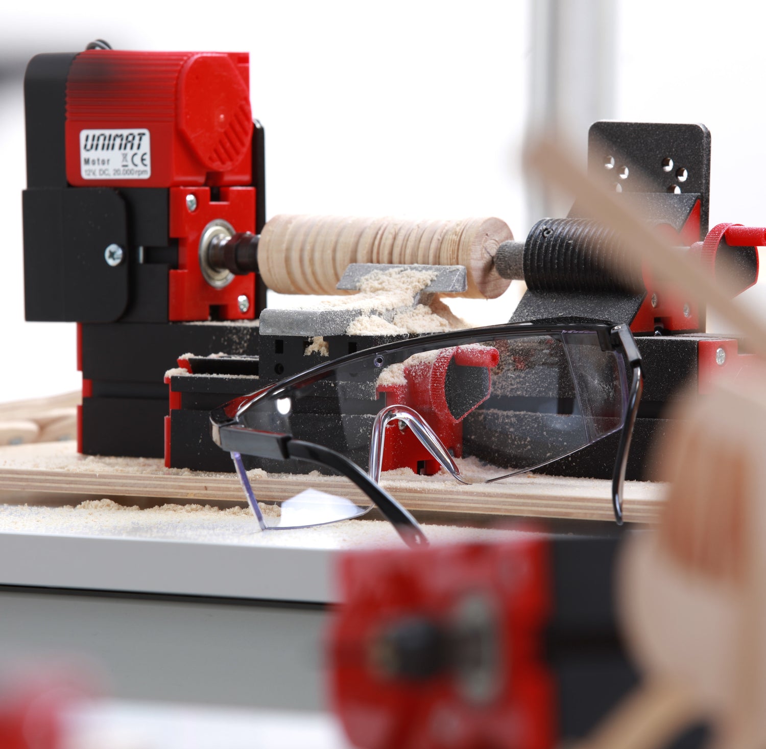 Drechselbank mit Schutzbrille und Holzmodellen