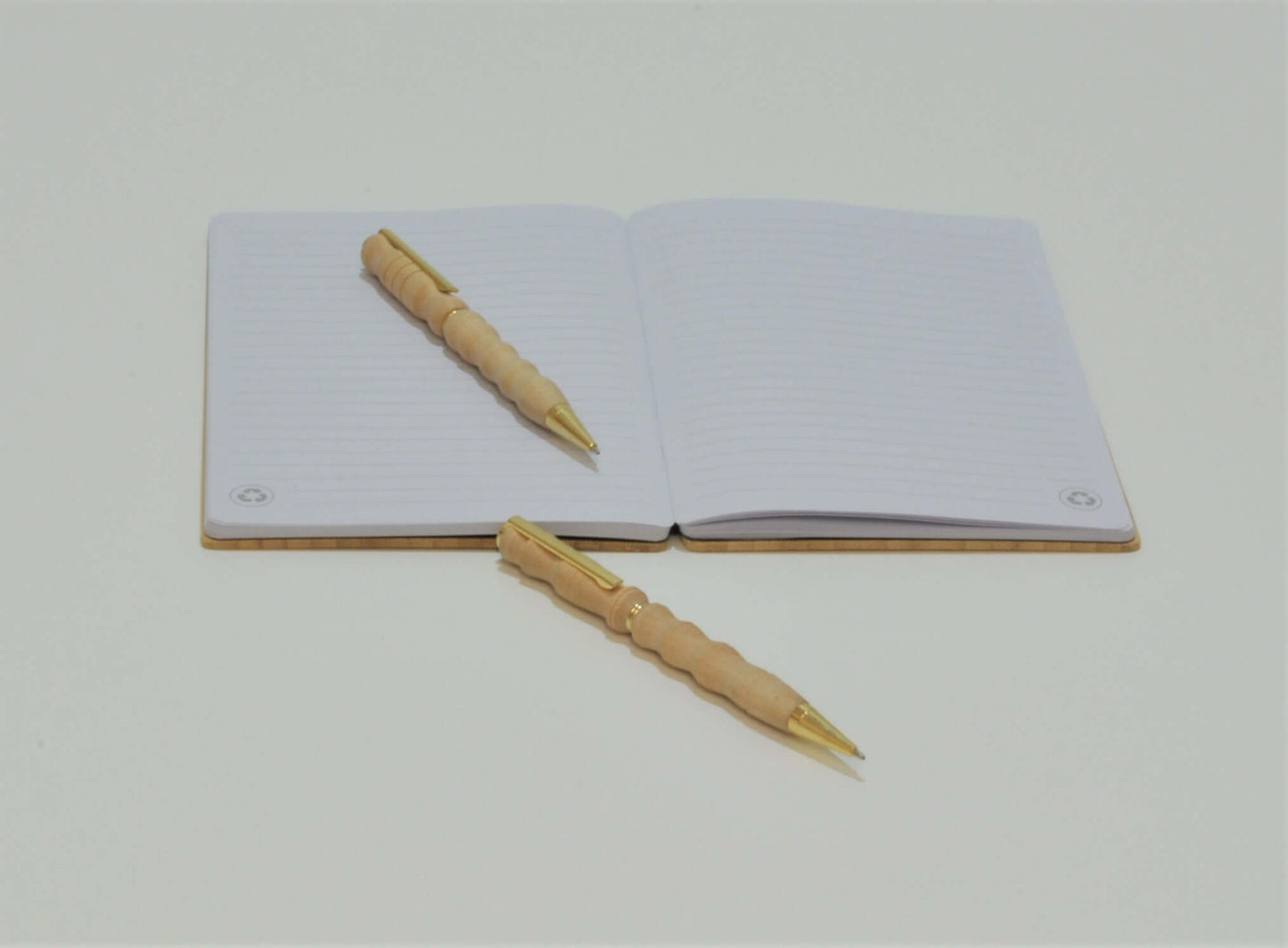 2 Holzkugelschreiber aus Ahorn auf einem Notizbuch
