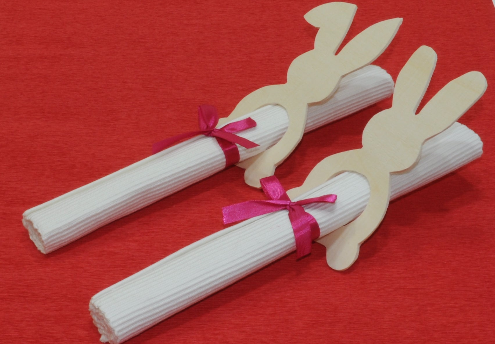 2 Serviettenhalter aus Holz im Osterhasenmotiv auf einem roten Tischtuch